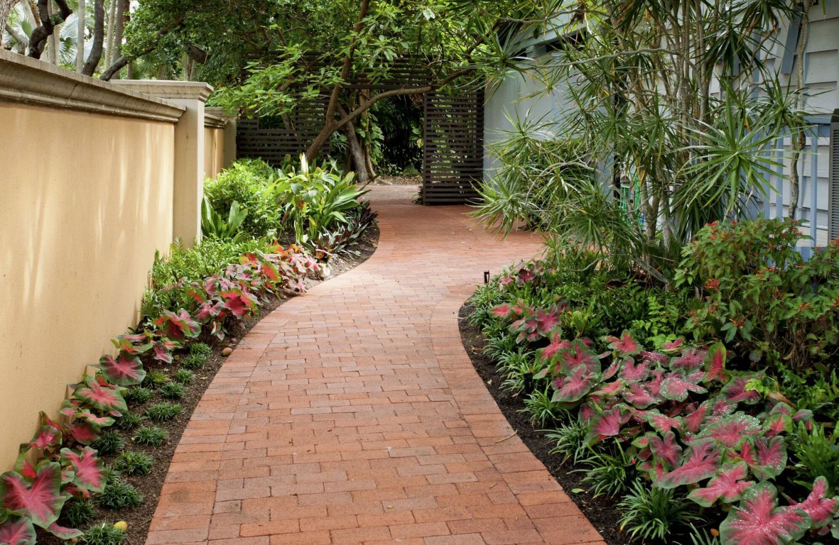 Curved brick pathway with fresh mulch and plant beds